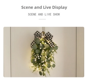 Close-up of lighted eucalyptus wreath with white berries and checkered bow