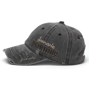 Detail showing side embroidery and distressed edges on the washed grey denim baseball cap