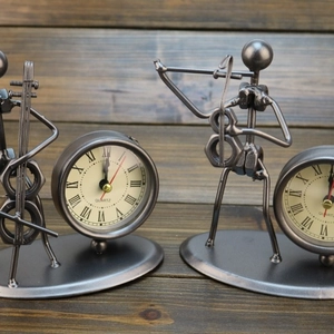 Vintage iron musician desk clock with Roman numerals displayed on a wooden surface