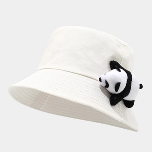 Close-up of white cotton bucket hat featuring a cute panda plush doll accessory on the brim