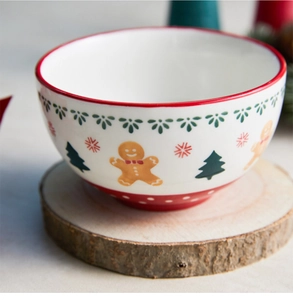 Detail view of a Christmas ceramic bowl with gingerbread man on a rustic wood base