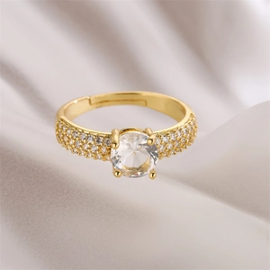 Vue macro d'une bague ajustable dorée avec une grande pierre centrale en zircone ronde