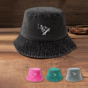 Detail showing washed denim bucket hat with skull skateboard print on a wooden surface