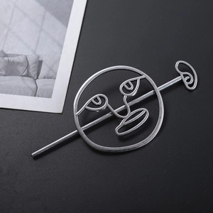 Abstract silver alloy hair stick featuring a cutout smiling face on a black background