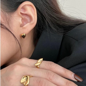 Golden heart earrings and irregular rings shown on a model with high polished finish