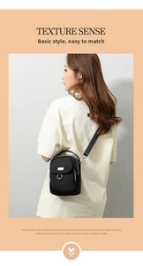 Close-up of black oxford crossbody bag with adjustable strap and metal ring detail