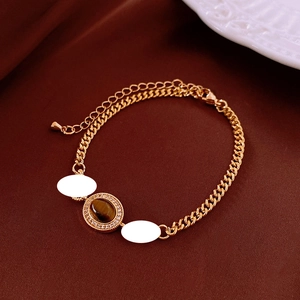 Detail of gold plated tiger eye bracelet with crystal bezel and adjustable chain link