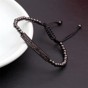 Macro shot of gunmetal beaded bracelet with colorful micro-set stones on a black leather background