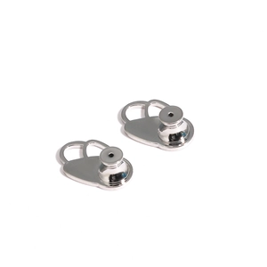 Close-up of polished silver earring lifter backs on a clean white background