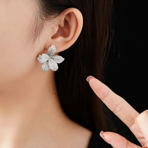 Detailansicht der Zirkonia Blumen-Ohrstecker mit glänzenden Blütenblättern am Modell