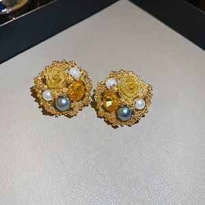 Macro detail of vintage floral earrings with gold metal, pearls and yellow crystals