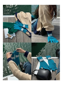 Detail of peacock blue knitted wool gloves with a premium white minimalist woven tag