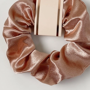 Elegant rose gold satin scrunchie with a glossy silk texture and voluminous pleats