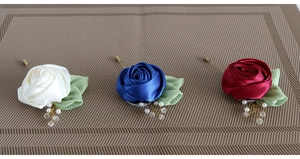 Detail of silk rose boutonnieres in white, royal blue and wine red with pearls