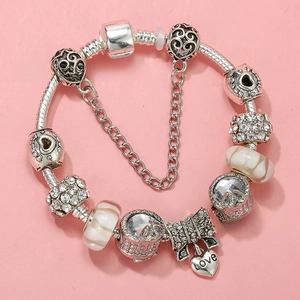 Detail view of heart-shaped Love pendant and beaded charm bracelet with safety chain