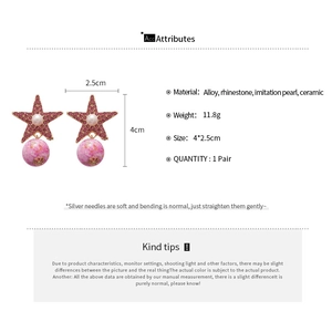Detailed view of star-shaped earrings with pink rhinestones, pearls and ceramic beads