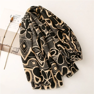Detail of printed scarf with floral geometric patterns and fringe edges on a magazine