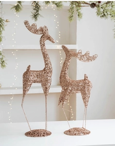 Detail view of two rose gold glitter wire reindeer statues with warm festive lights