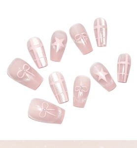 Detailed view of pink cat-eye press-on nails with white bows, stars, and glitter finish