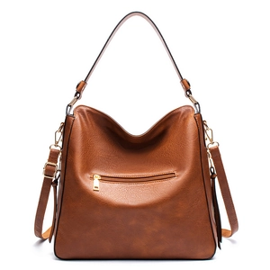 Close-up of caramel brown pebble leather texture and gold zipper detail on shoulder bag