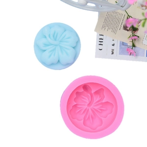 Stampo in silicone rosa a forma di ibisco per saponi e candele su sfondo bianco
