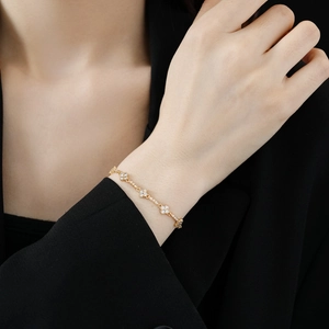Detail of adjustable gold bracelet featuring cubic zirconia flower clusters on wrist