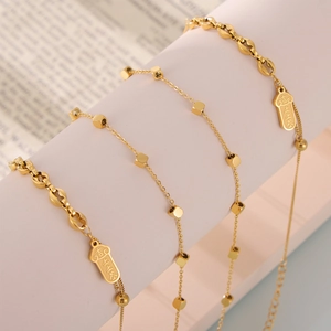 Bracelet de cheville en acier titane doré avec cubes et breloque porte-bonheur sur support