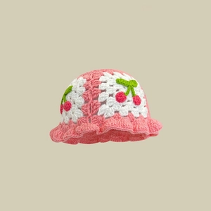 Detail der Strickstruktur vom rosa-weißen Häkelhut mit handgefertigter Kirschverzierung