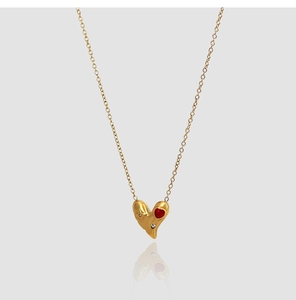 Détail d'un pendentif cœur plaqué or 18 carats avec mini cœur rouge et diamants blancs