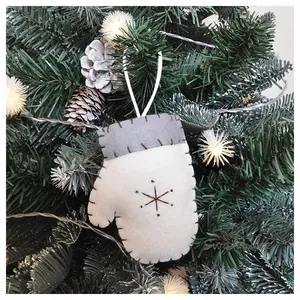 Close-up of white felt Christmas glove ornament with brown snowflake embroidery and rope