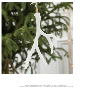 White frosted reindeer antler hanging on a Christmas tree branch with rustic twine hook