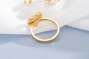 Détail d'une bague coeur en or poli sur socle bleu clair avec fond floral élégant