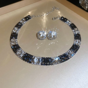 Macro view of blue and clear cubic zirconia necklace and earrings with silver base