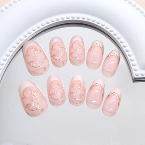 Pink jelly press-on nails with golden floral patterns and oval shape in a luxury set