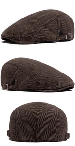 Detail of herringbone tweed cap showing side adjustable metal buckles and fabric texture