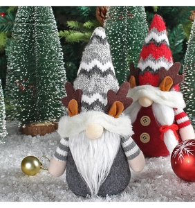 Gros plan de gnomes de Noël gris et rouges avec bois de renne dans une scène de neige festive
