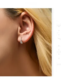 Détail d'une boucle d'oreille en argent s925 avec zircons brillants portée par un mannequin