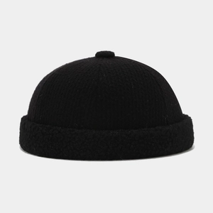 Detail of knitted brimless docker cap with thick fleece cuff and top knit ball