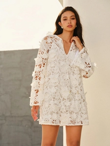 Détail de la broderie en dentelle blanche et du col en V avec cordon sur cette robe de plage