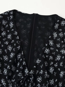 Detailansicht des Rückens eines schwarzen Blumen-Chiffonkleids mit Reißverschluss