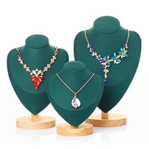 Three-tier green velvet and wood necklace display stands with assorted jewelry