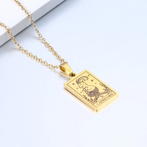 Detailed close-up of a gold Capricorn zodiac pendant on a stainless steel chain