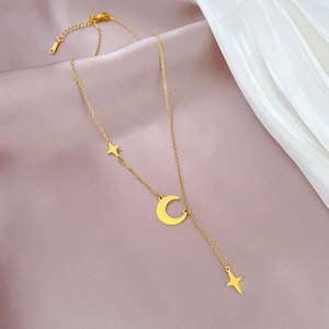 Detail of gold moon and star pendant on a Y-shaped titanium steel necklace chain