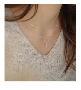 Detailed view of a gold slim bar pendant with micro-set diamonds on a minimalist chain