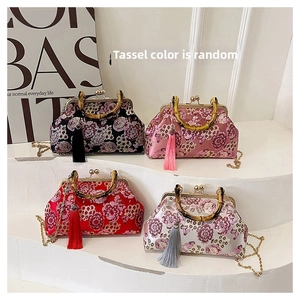 Close-up of Chinese floral embroidery shell bags with natural bamboo handles and silk tassels