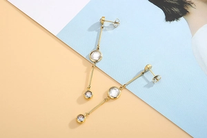 Detailed close-up of gold-plated tassel earrings with sparkling round cubic zirconia