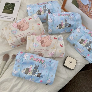 Detail of roll-up toiletry bag featuring puppy prints and secure strap closure