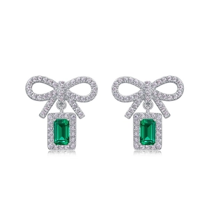Boucles d'oreilles nœud avec pierre verte taille émeraude sur fond blanc pur