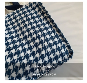 Close-up of precise computer stitching on a blue houndstooth canvas tote bag