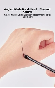 Detailed view of ultra-thin angled eyeliner brush drawing precise lines on the skin